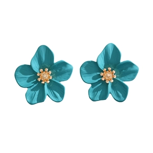 Detailed close-up of peacock blue flower stud earrings with a golden metallic center