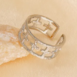 Adjustable silver open ring featuring cross cut-outs on a minimalist textured surface