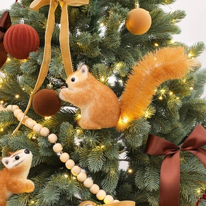 Christmas squirrel and fox ornaments with velvet bows on tree branches decoration
