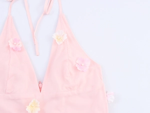 Détail de la robe licou rose avec fleurs 3D et centres en perles sur tissu léger