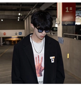 Collier à grosse chaîne argentée porté avec un blazer noir et un t-shirt pour hommes