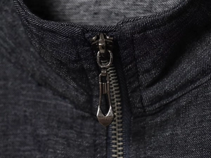 Vue détaillée de la fermeture éclair en métal et de la texture du tissu denim foncé