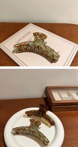 Detail view of acetate claw clips in tortoiseshell patterns on a wooden surface