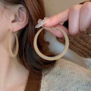 Macro detail of large khaki velvet hoop earrings worn on ear for vintage style