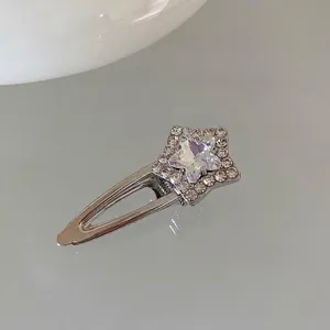 Detailed macro view of silver star hair clip with pink aurora stone and rhinestones