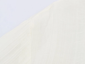 Macro shot of the white textured fabric weave on this minimalist loose-fit commuter shirt