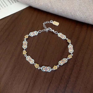 Macro detail of vintage enamel flower bracelet with blue beads and silver-tone chain