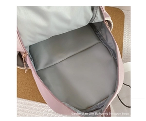 Spacious main compartment of a pink backpack with gray fabric lining and zipper closure