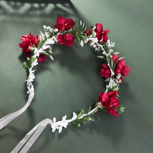 Top view of red and white floral bridal headband with green leaves and ribbon