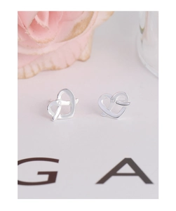 Macro shot of S925 silver hollow heart earrings with a delicate inlaid gemstone detail