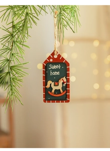 Détail d'une étiquette de Noël en bois avec cheval à bascule sur une branche de sapin