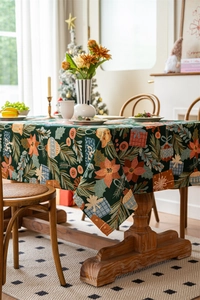 Close-up of festive jacquard weave featuring poinsettias and pine on a dark green tablecloth