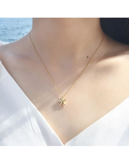 Close-up of gold starfish pendant necklace worn elegantly on a female model neck