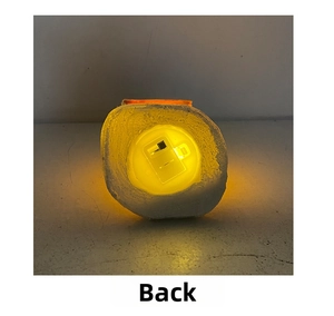 Detail view of the battery compartment and toggle switch on the glowing resin house base