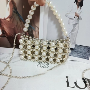 Detail of hand-woven beaded handbag in silver and cream pearls with long crossbody chain