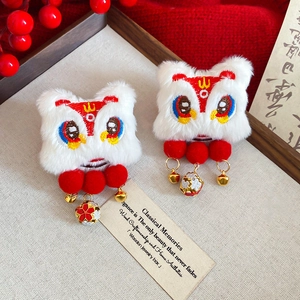 Detail of red and white lion dance hair clips with golden bells and embroidery