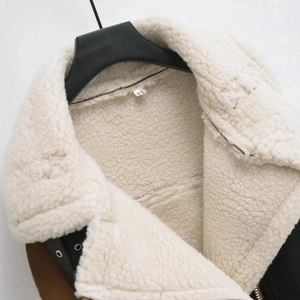 Nahaufnahme der Lammfellimitat-Weste in Beige und Braun mit Reißverschluss-Details