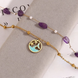 Detail of 18K gold anklet featuring purple natural stones and whale tail pendant