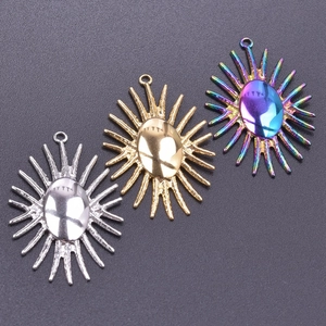 Three oval sunburst pendants in silver, gold, and rainbow finish on dark background