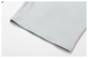 Detail of the high-quality double-needle hem on light blue athletic yoga top fabric