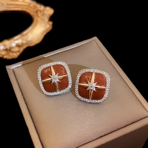 Nahaufnahme vintage quadratische Ohrstecker mit Bernsteinharz und Goldstern-Zirkonia