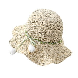 Handmade wide-brim straw sun hat with decorative white tulips and green vine ribbon