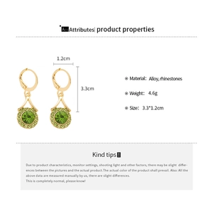 Detail view of vintage gold-tone earrings with green crystals and 3.3cm size specs