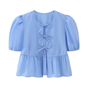 Elegant blue puff sleeve top with decorative bow ties and peplum hem on white background