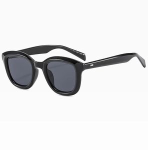 Detail view of the thick black retro frame and dark lenses of these fashion sunglasses