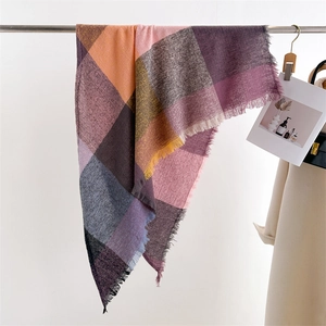 Close-up of colorful checkered scarf with soft tassels and woven plaid texture
