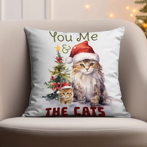 Detail of Christmas cat pillow with You Me & THE CATS print on a cozy sofa