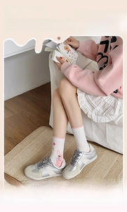 Détail de chaussettes en coton blanc à mi-mollet avec bord rose et motif de lapin mignon