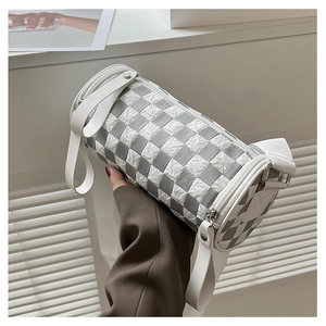 Detail of checkered cylinder shoulder bag with textured fabric and wide strap