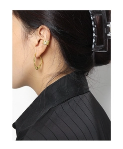 Close-up of gold irregular ring earring and hammered ear cuff on a model's ear
