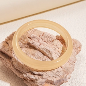 Close-up of translucent amber resin geometric round bangle on a natural pink stone