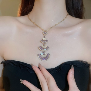 Detailed close-up of layered fan-shaped pendant necklace with purple pear-shaped crystals