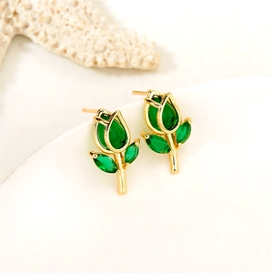 Close-up of gold tulip stud earrings with inlaid green gemstones on a white tray