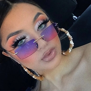 Close-up of rimless gradient purple square sunglasses and gold bamboo hoop earrings