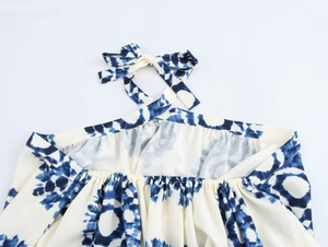Close-up of halter neckline with blue tie-dye print and adjustable bow tie strap