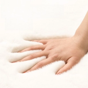Macro detail of thick faux rabbit fur rug showing soft plush texture and high density
