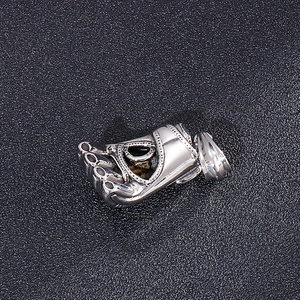 Detailed view of a silver stainless steel foot-shaped pendant with beaded texture