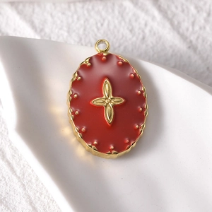 Macro shot of 14k gold square evil eye pendant with red enamel clover detail