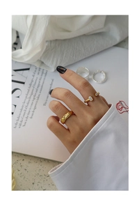 Detail of gold textured S925 silver ring set with opal stone on a model's hand