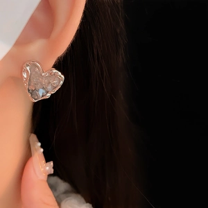Gros plan de boucles d'oreilles cœur argentées avec une texture de cristal étincelante
