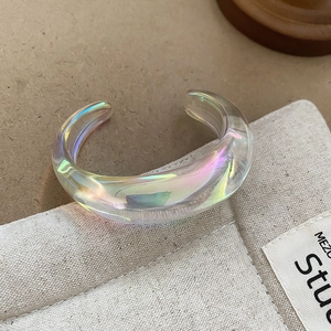 Detailed view of iridescent acrylic resin wide open bangle with Aurora coating finish