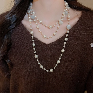 Détail du collier élégant à trois rangs de perles et de pierres œil-de-chat pour femme