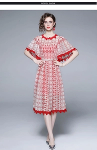 Details von roten Blumenstickereien und ausgestellten Ärmeln am eleganten Kleid
