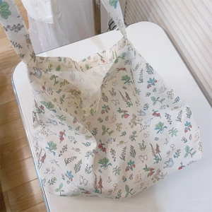 Detail of floral and animal prints on cream cotton canvas tote bag with shoulder strap