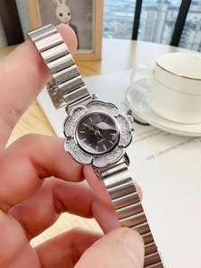 Detail of silver stretch metal watch strap and flower-shaped case with sparkling texture