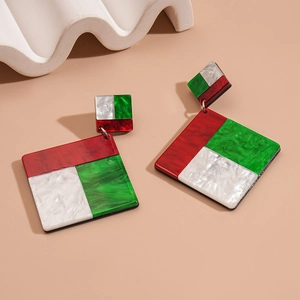 Macro shot of geometric acrylic earrings with red green and marbled white square panels